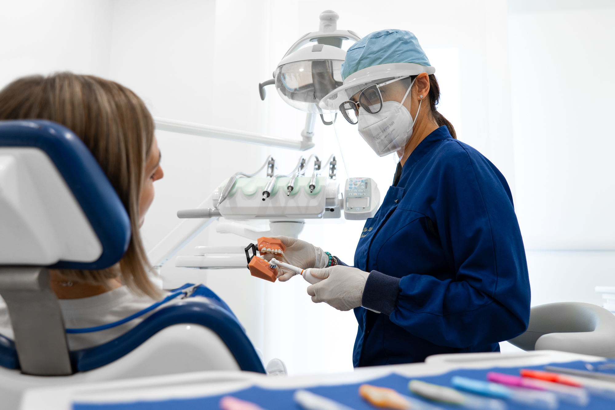 dottoressa che mostra alla paziente come si spazzolano i denti